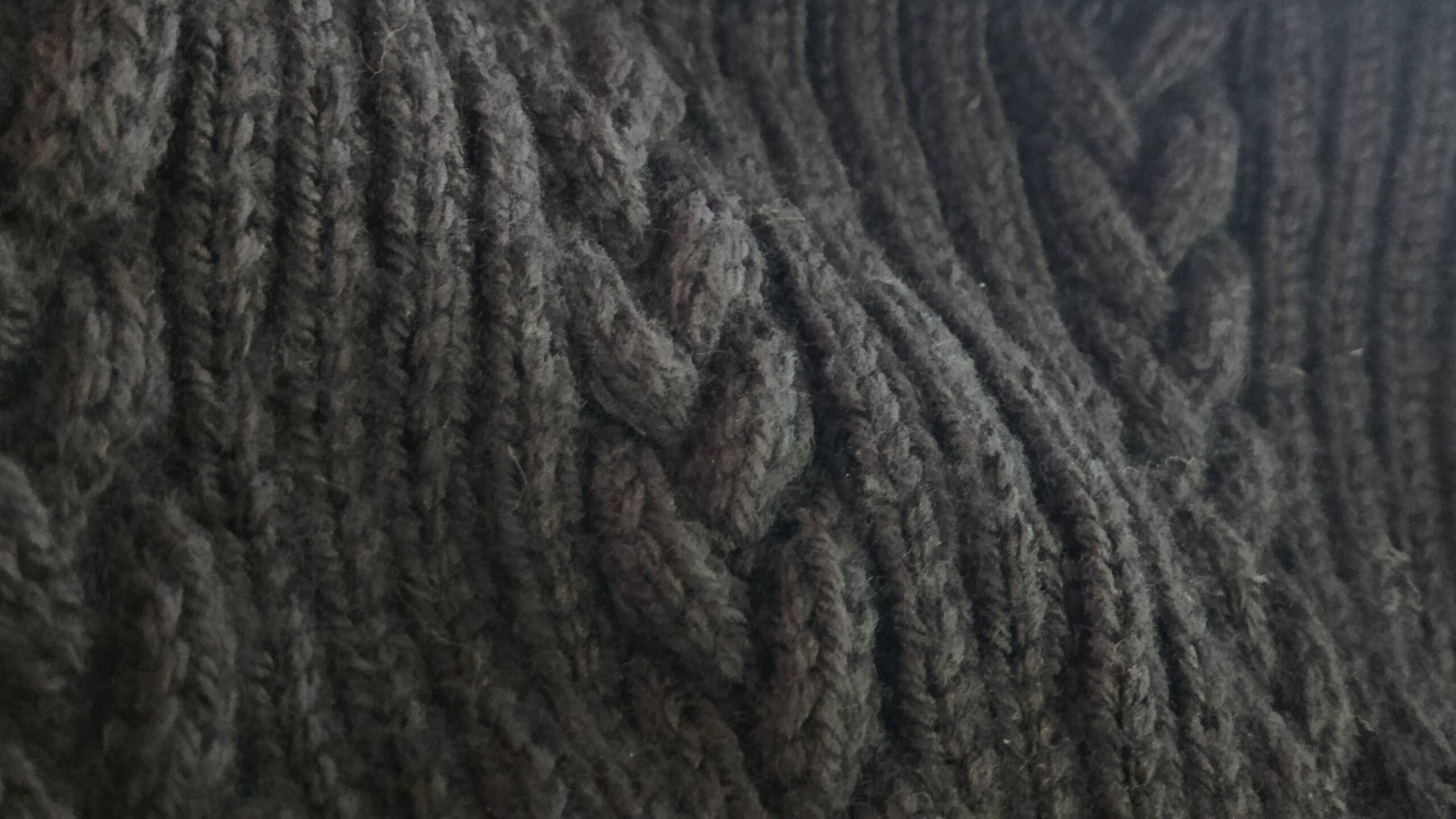 A close-up image of the braided cables on the Hopsmere sweater sleeve.